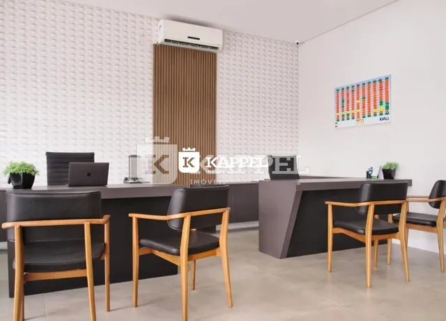 Cozinha moderna com ilha escura e assentos em frente a um painel de parede.