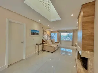 Sala de estar com piso de cerâmica e parede de destaque em imóvel em Lajeado.