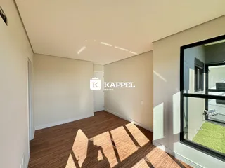 Foto de um cômodo interno com piso de madeira e uma grande janela.
