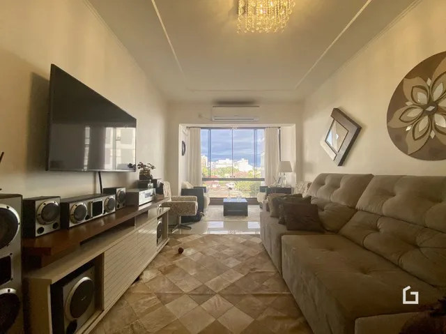 Sala de estar com sofá e televisão em um imóvel no Brasil.