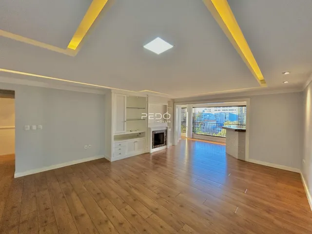 Sala de estar com piso de madeira e teto moderno em imóvel no Brasil.