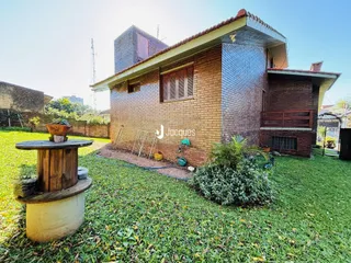 Fachada de uma casa de tijolos com jardim gramado.