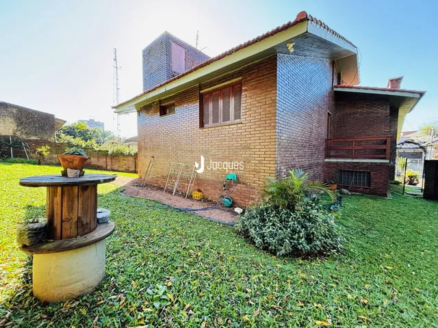 Fachada de uma casa de tijolos com jardim gramado.