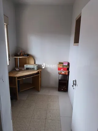 Interior de um cômodo com paredes brancas e piso de cerâmica.