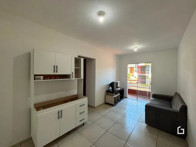 Ambiente interno de uma sala com cozinha e sofá em um imóvel.