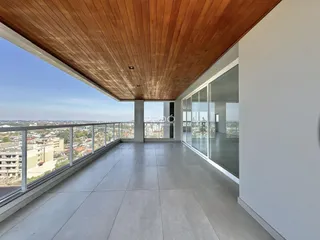 Vista panorâmica de um terraço com piso de cerâmica e teto de madeira.
