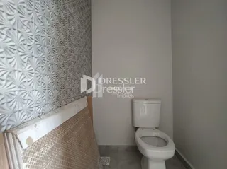 Foto de um ambiente interno mostrando uma parede texturizada e um vaso sanitário branco.