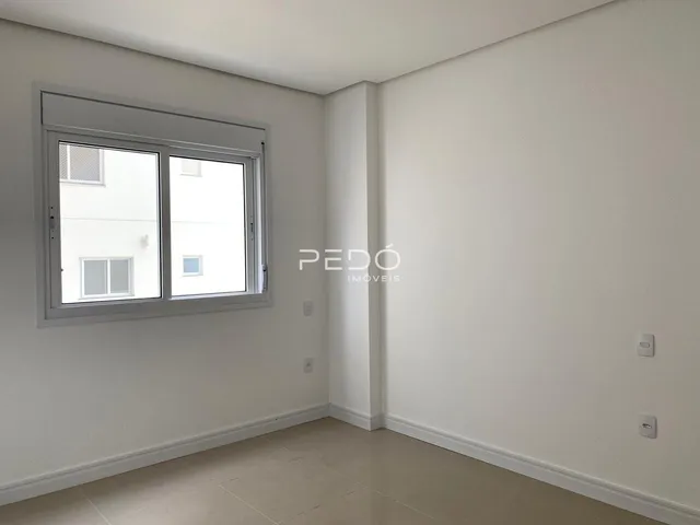 Ambiente interno de uma sala com paredes brancas e piso claro.