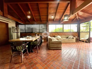 Sala de estar com piso de tijolos vermelhos e teto de madeira.