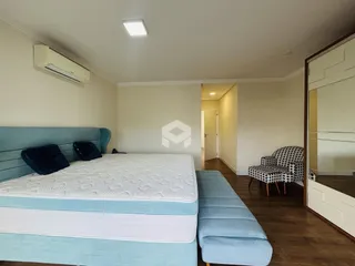 Quarto com cama azul e piso de madeira.