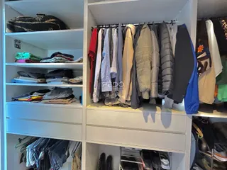 Prateleiras com roupas penduradas em um ambiente interno.