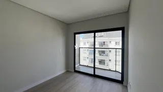 Interior de um cômodo com paredes cinzas e piso de madeira clara.