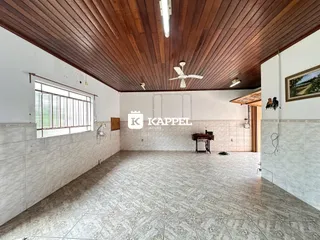 Uma sala ampla com piso de cerâmica e forro de madeira.
