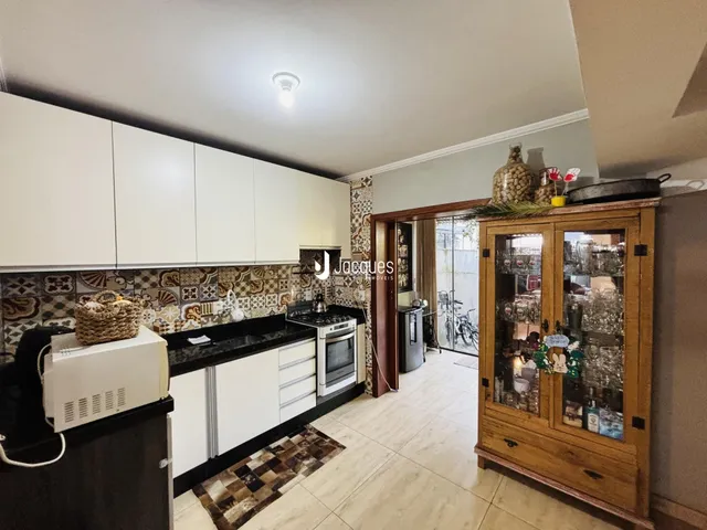 Imagem de uma cozinha com armários brancos e revestimento de azulejos na Lajeado, Brasil.