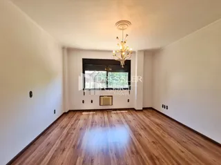 Sala de estar com piso de madeira clara e paredes brancas.