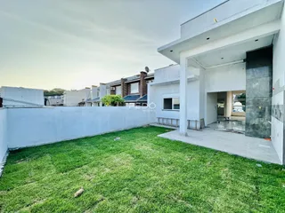 Fachada de uma residência moderna com jardim gramado.