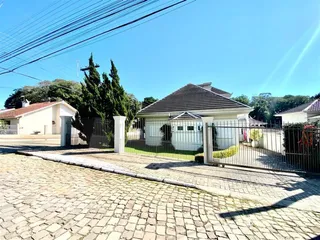 Fachada de uma casa em Lajeado, Brasil, com cerca e calçada de paralelepípedos.