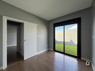 Hall de entrada com piso de madeira e porta de vidro voltada para o jardim.