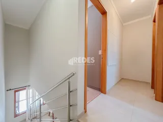 Hall da escada com corrimão de metal em um imóvel.