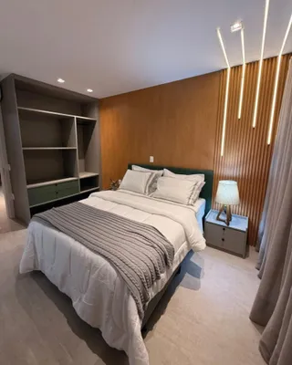 Quarto moderno com cama grande e estante embutida.