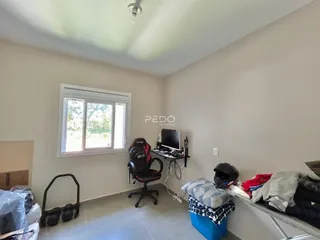 Quarto com janela e mesa de trabalho em um imóvel no Brasil.