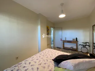 Quarto interno com cama e paredes claras.