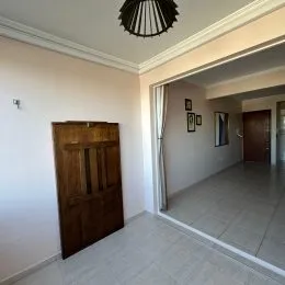 Hall de entrada com porta de madeira em um ambiente interno.