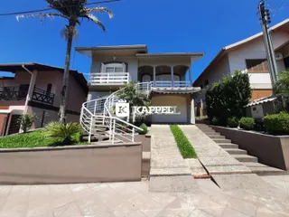 Fachada de uma casa residencial em Lajeado, Brasil, com escadaria externa e jardim.