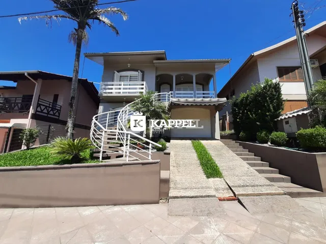 Fachada de uma casa residencial em Lajeado, Brasil, com escadaria externa e jardim.