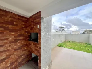 Parede interna com revestimento de tijolo aparente e parede de concreto em uma residência.