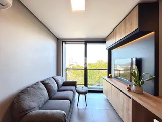 Sala de estar com grandes janelas e vista externa.