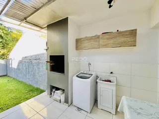 Imagem de uma área interna com parede de tijolos e acesso ao quintal.