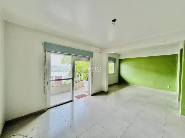 Ambiente interno de uma sala com piso de cerâmica e porta de vidro abrindo para o exterior.