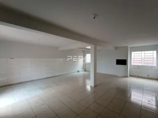 Vista de um corredor interno com piso de cerâmica clara.