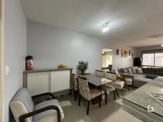 Sala de estar com sofá e mesa de jantar em um imóvel no Brasil.