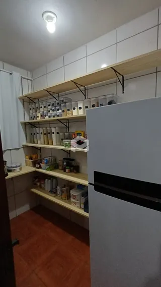 Interior da cozinha com prateleiras de madeira e revestimento branco.