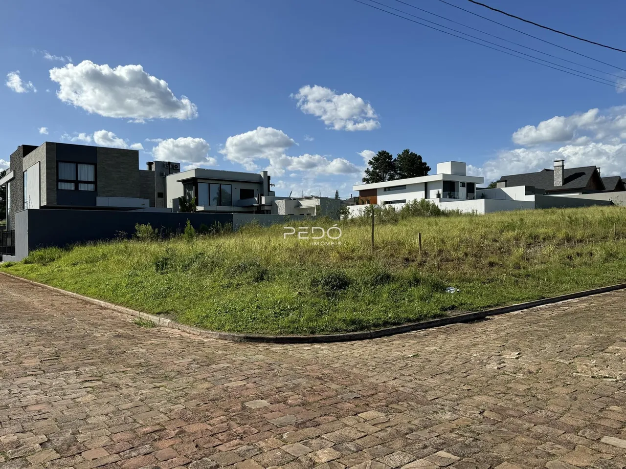 Vista externa de residências modernas em Lajeado, Brasil, com área gramada em primeiro plano.