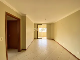Hall de entrada com piso de cerâmica clara e paredes bege.