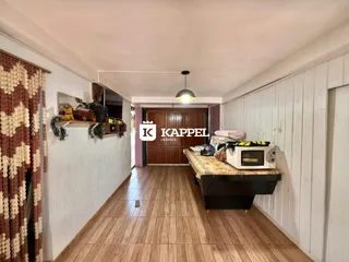 Hall de entrada com piso de madeira e decoração na parede.