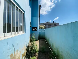 Vista externa de uma parede azul com janela em uma residência no Brasil.