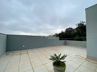 Área externa com piso de cerâmica e parede cinza.