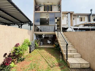 Fachada de uma residência em Lajeado, Brasil, com jardim frontal e escadaria.