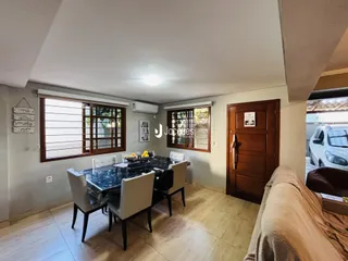 Foto de uma sala de jantar com piso de madeira e grandes janelas em Lajeado.