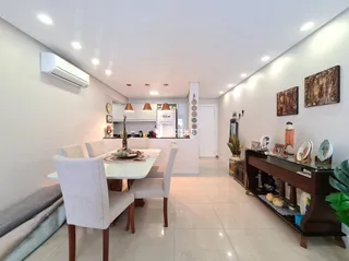 Sala de jantar com mesa e cadeiras em ambiente claro.