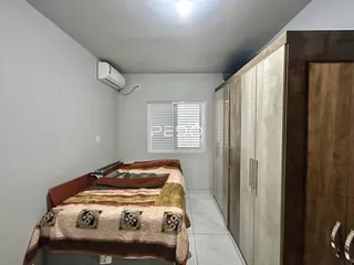 Quarto com cama e armário de madeira em um imóvel no Brasil.