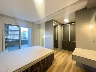 Quarto com cama e armários em um apartamento em Lajeado.