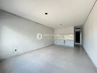 Interior de um corredor ou área comum com paredes brancas e piso claro.