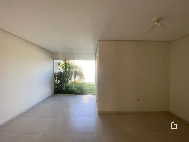 Vista interna de um ambiente com paredes brancas e piso claro.