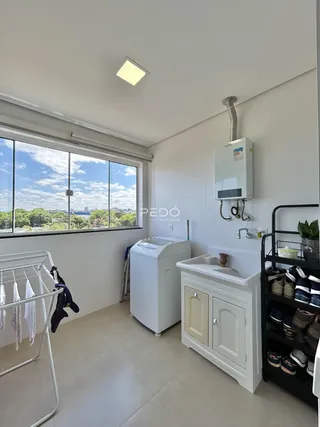 Foto de um cômodo interno com janela e máquina de lavar roupa.