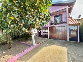 Foto da fachada de uma residência em Lajeado, Brasil, mostrando o jardim frontal.